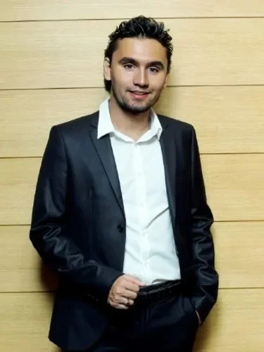 A man in a suit standing next to a wall