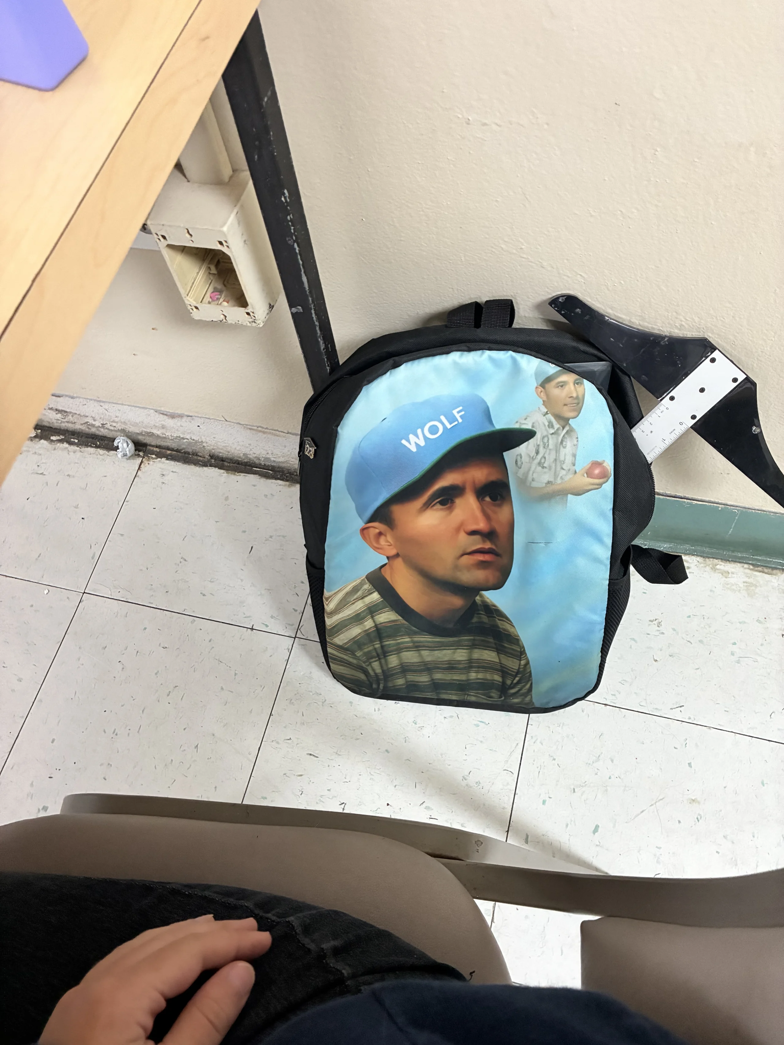A person sitting on the floor with a backpack