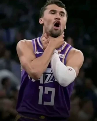 A man in a purple jersey is holding a basketball ball