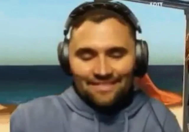 A man in headphones is sitting on a beach