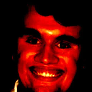 A man smiling with a red light on his face