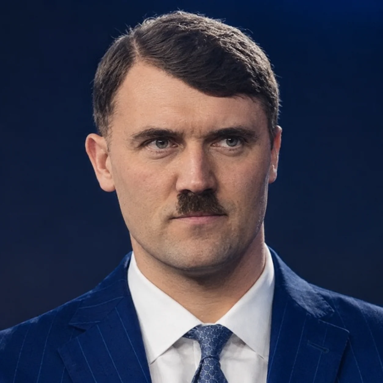 A man in a suit and tie with a mustache