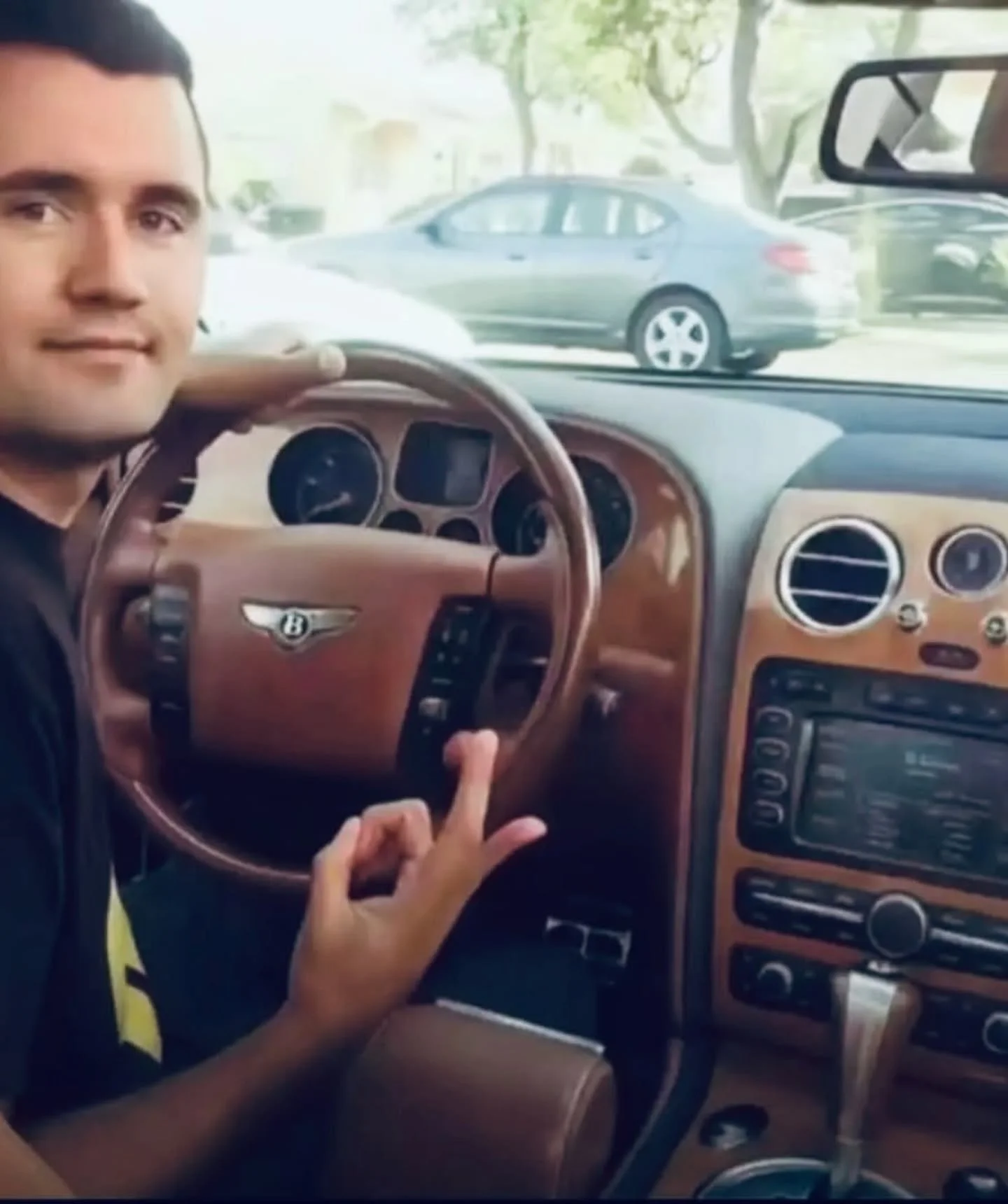 A man sitting in the driver ' s seat of a car