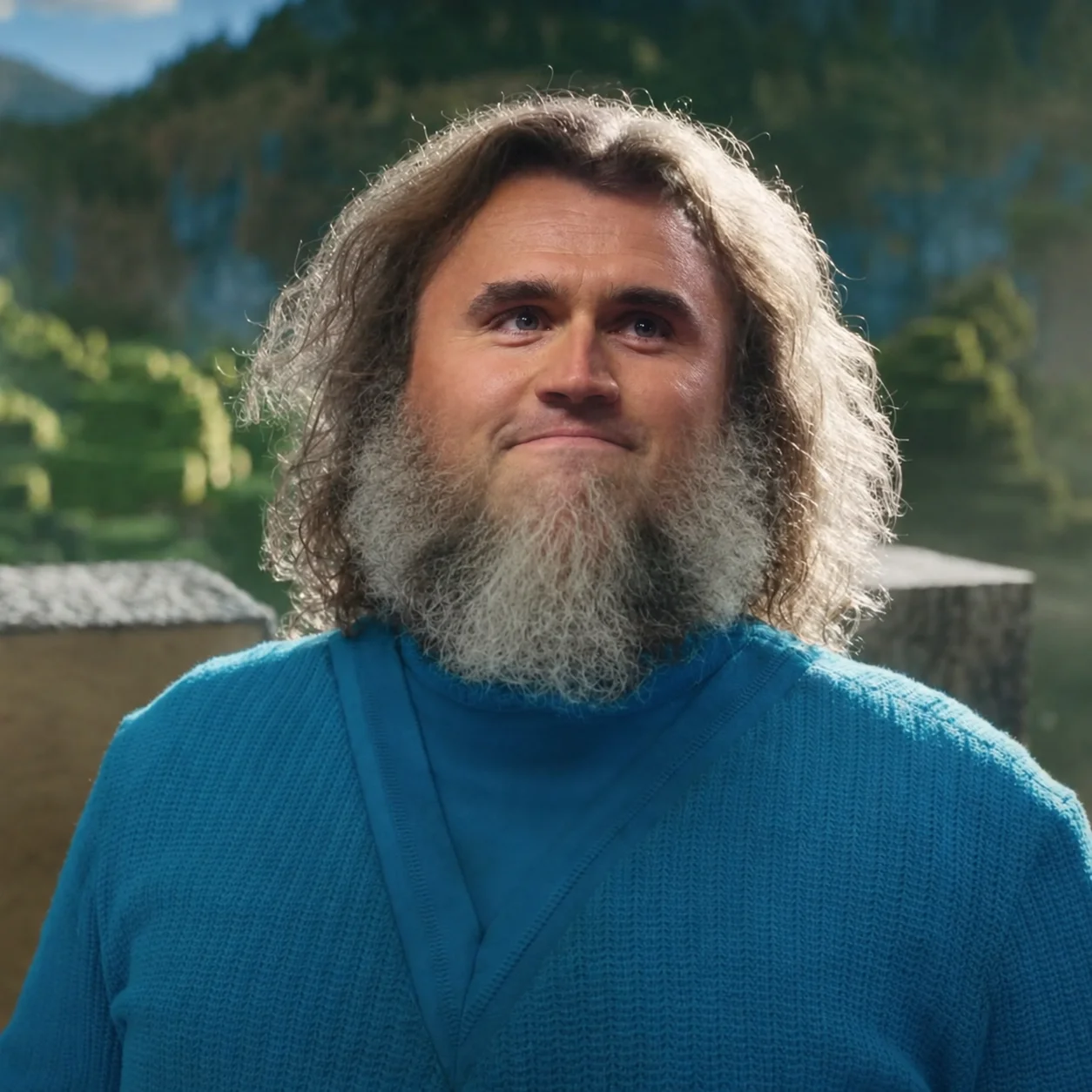 A man with long hair and beards stands in front of a mountain