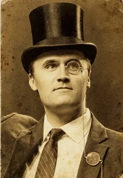 A man in a top hat and tie with a cane