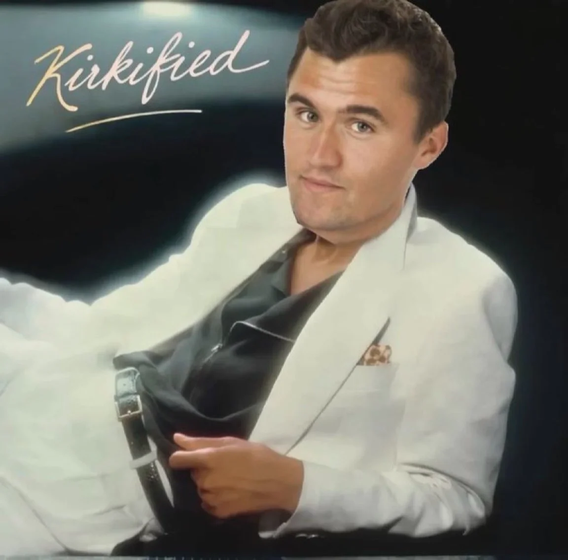 A man in a white suit and tie holding a cell
