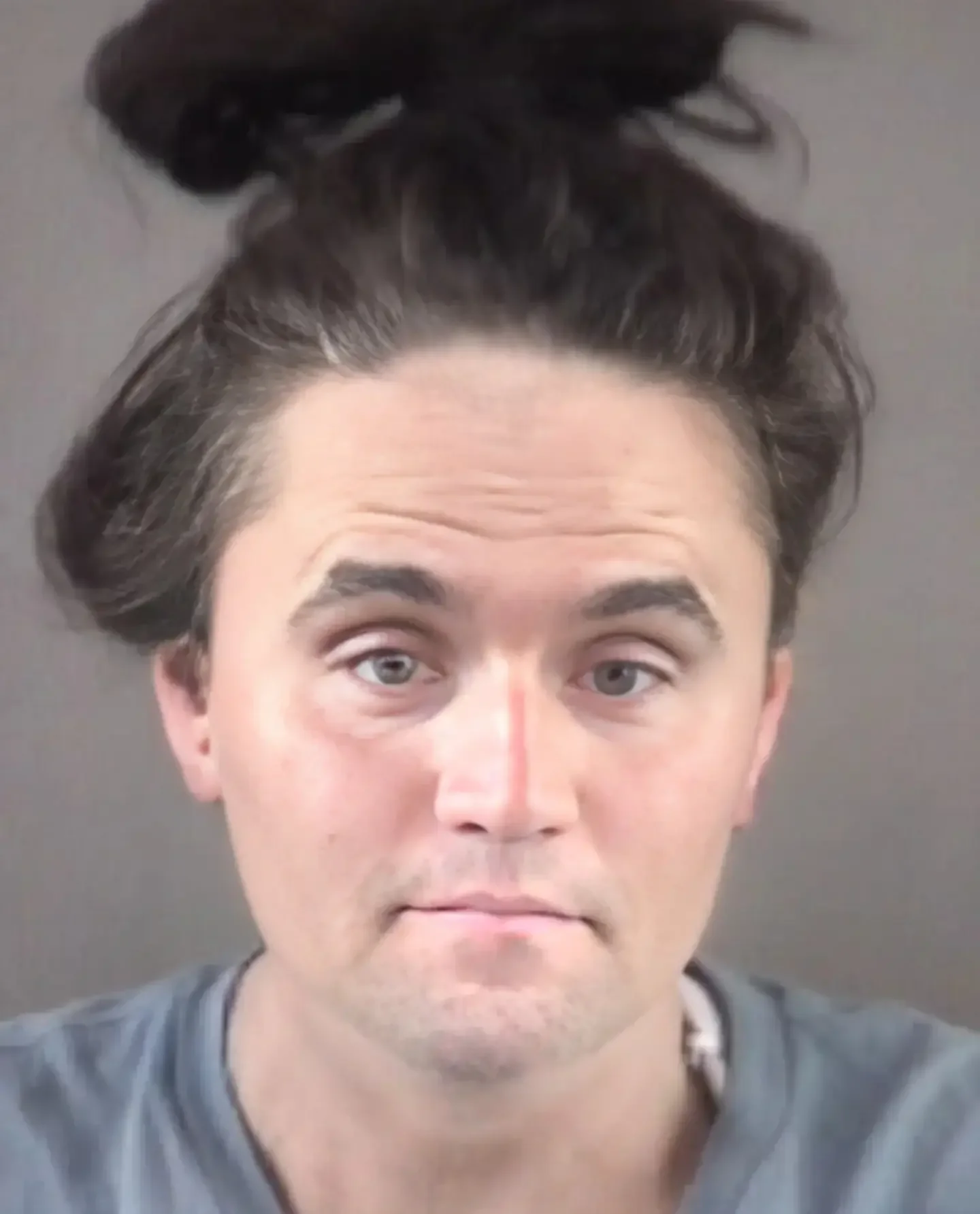 A man with a messy top knot on his head