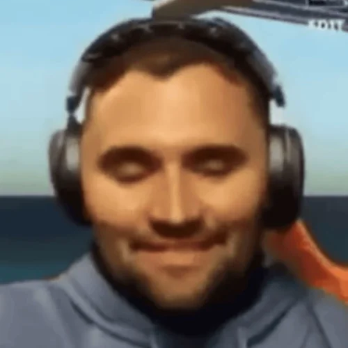 A man in a blue shirt is sitting in front of a plane