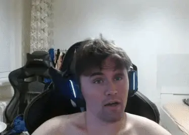A man with no shirt sitting in a chair
