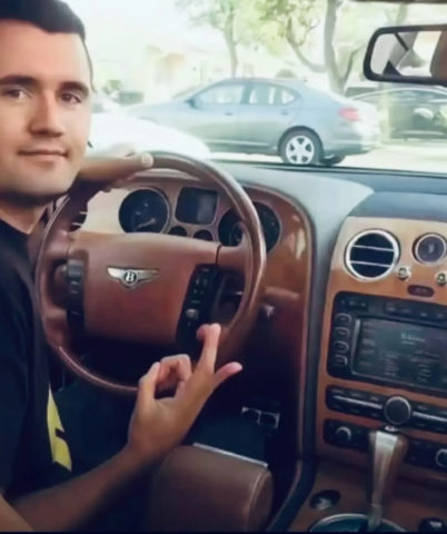 A man sitting in the driver ' s seat of a car