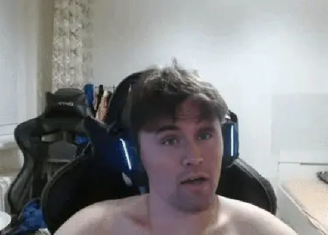 A man with no shirt sitting in a chair